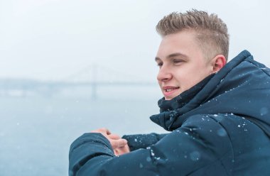 Portrait of young blonde guy Nordic appearance, lifestyle of young people. Handsome guy close up, winter day thinking about something