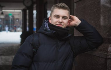 Portrait of young blonde guy Nordic appearance, lifestyle of young people. Handsome guy close up, winter day thinking about something