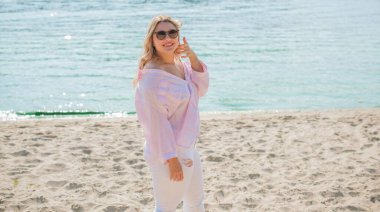 Tatil havası. Ayrıca plajda, baharda, yaz kıyafetleri koleksiyonunda boy mutlu bir kız.