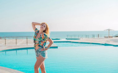 Artı oteldeki ırkları karıştıran boyda genç bir kadın, hayatın tadını çıkar, plaj kıyafetleri. XI ölçülerinde, mutlu, güzel, güzel bir bayan.