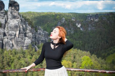 Turizm konsepti, oldukça romantik bir kadın dağlardaki güzel manzaraya, Sakson İsviçre 'deki tatile bakıyor.