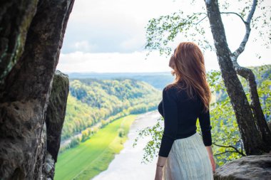 Turizm konsepti, oldukça romantik bir kadın dağlardaki güzel manzaraya, Sakson İsviçre 'deki tatile bakıyor.