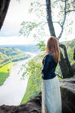 Turizm konsepti, oldukça romantik bir kadın dağlardaki güzel manzaraya, Sakson İsviçre 'deki tatile bakıyor.