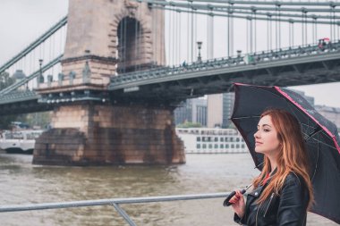 Avrupa 'da turizm, tatil konsepti. Güzel bir kadın şehrin merkezindeki caddelerin manzarasına bakar. Budapeşte 'ye yolculuk