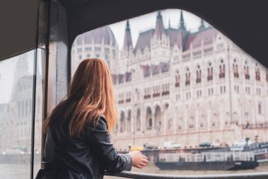 Avrupa 'da turizm, tatil konsepti. Güzel bir kadın şehrin merkezindeki caddelerin manzarasına bakar. Budapeşte 'ye yolculuk