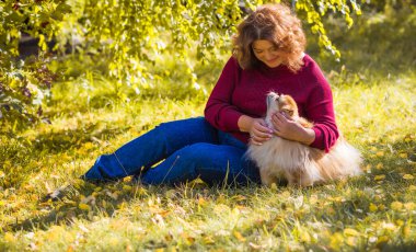 Küçük altın köpeği olan hoş bir bayan, evcil hayvan konsepti, köpek en iyi insan dostudur.