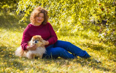Küçük altın köpeği olan hoş bir bayan, evcil hayvan konsepti, köpek en iyi insan dostudur.