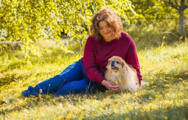 Küçük altın köpeği olan hoş bir bayan, evcil hayvan konsepti, köpek en iyi insan dostudur.