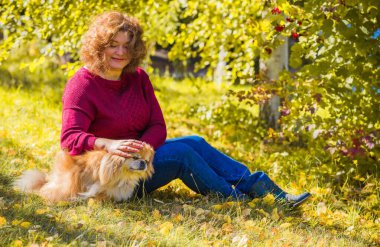 Küçük altın köpeği olan hoş bir bayan, evcil hayvan konsepti, köpek en iyi insan dostudur.