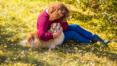 Küçük altın köpeği olan hoş bir bayan, evcil hayvan konsepti, köpek en iyi insan dostudur.