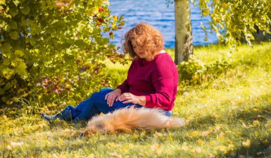 Küçük altın köpeği olan hoş bir bayan, evcil hayvan konsepti, köpek en iyi insan dostudur.