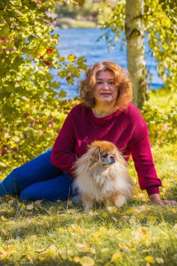 Küçük altın köpeği olan hoş bir bayan, evcil hayvan konsepti, köpek en iyi insan dostudur.