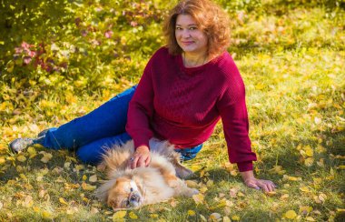 Küçük altın köpeği olan hoş bir bayan, evcil hayvan konsepti, köpek en iyi insan dostudur.