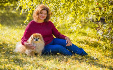 Küçük altın köpeği olan hoş bir bayan, evcil hayvan konsepti, köpek en iyi insan dostudur.