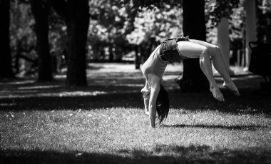 Mutlu kadın hayatın tadını çıkarıyor, eğleniyor ve şehir parkında jimnastik yapıyor. Yaz güneşli günler ve keyifli günler.