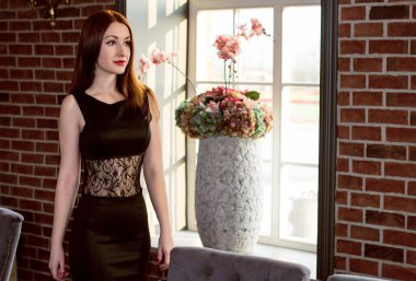 Siyah tiyatro dantelli elbisesi, parlak ayakkabıları ve klasik mücevherleri olan güzel kızıl saçlı bir kadın, retro makyaj, ormanın yakınında, yolda, sahne arkasında, klasik arka planda, ilham verici bir modda,