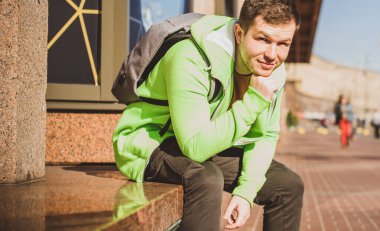 Güzel bir açık hava portresi. Şehrin sokaklarındaki adam, gülümseyen insanlar konsepti, iyi ruh hali ve olumlu duygular.