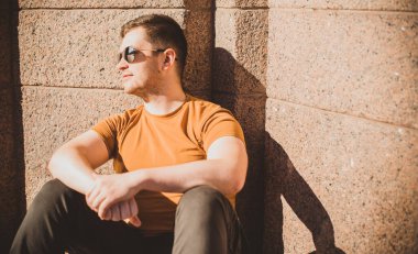 Güzel bir açık hava portresi. Şehrin sokaklarındaki adam, gülümseyen insanlar konsepti, iyi ruh hali ve olumlu duygular.