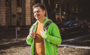 Güzel bir açık hava portresi. Şehrin sokaklarındaki adam, gülümseyen insanlar konsepti, iyi ruh hali ve olumlu duygular.