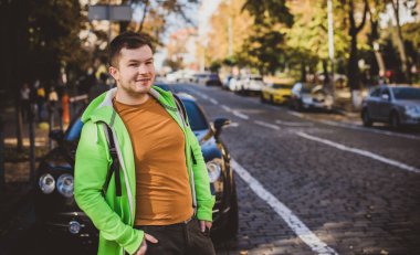 Güzel bir açık hava portresi. Şehrin sokaklarındaki adam, gülümseyen insanlar konsepti, iyi ruh hali ve olumlu duygular.