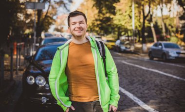 Güzel bir açık hava portresi. Şehrin sokaklarındaki adam, gülümseyen insanlar konsepti, iyi ruh hali ve olumlu duygular.