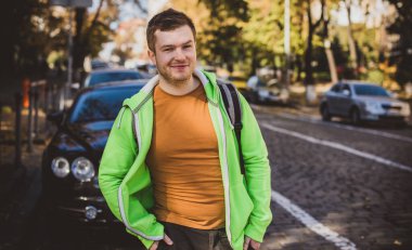Güzel bir açık hava portresi. Şehrin sokaklarındaki adam, gülümseyen insanlar konsepti, iyi ruh hali ve olumlu duygular.