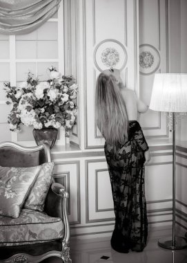 Erdemli bir kadın yatak odasında. Erotik pozlarda yarı çıplak seksi bir kadın. Fuhuş ve eskort konsepti