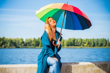 Parkta şemsiyeyle yürüyen alımlı genç bir kız, sonbahar ya da bahar günü. Hava ve insan konsepti. Doğada şemsiyesi olan hoş bir bayan. İngiltere yağmuru
