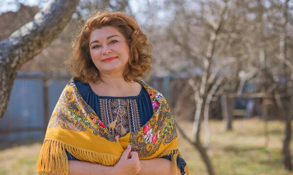 European Plus size ethnic woman in embroidery traditional shirt and scarf. Concept of national costume. Eastern Europe traditional style