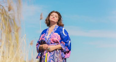 Ayrıca sarı etekli kadın ve Boho etnik esrarengiz hırka giyiyor. Kadınlar için moda, yeni koleksiyon 