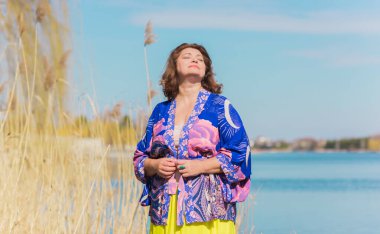 Ayrıca sarı etekli kadın ve Boho etnik esrarengiz hırka giyiyor. Kadınlar için moda, yeni koleksiyon 