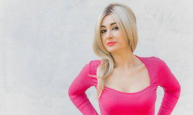 Klasik kız pembe tonlu Barbie bebeğe benziyor. Sarışın kadın makyaj malzemesi pembe kazak giyer, şık bir konsept.