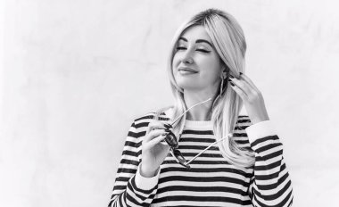  60 'lar-70' ler görünüşü. Sarışın kadın makyaj malzemesi çizgili kazak, modaya uygun bir konsept.