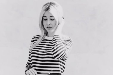  60 'lar-70' ler görünüşü. Sarışın kadın makyaj malzemesi çizgili kazak, modaya uygun bir konsept.