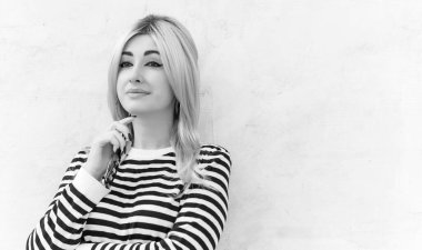  60 'lar-70' ler görünüşü. Sarışın kadın makyaj malzemesi çizgili kazak, modaya uygun bir konsept.