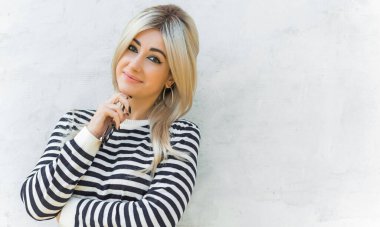  60 'lar-70' ler görünüşü. Sarışın kadın makyaj malzemesi çizgili kazak, modaya uygun bir konsept.