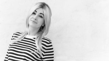  60 'lar-70' ler görünüşü. Sarışın kadın makyaj malzemesi çizgili kazak, modaya uygun bir konsept.