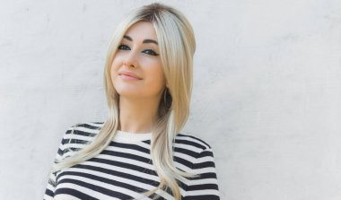  60 'lar-70' ler görünüşü. Sarışın kadın makyaj malzemesi çizgili kazak, modaya uygun bir konsept.