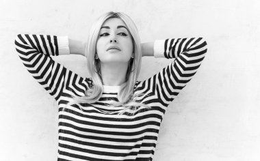  60 'lar-70' ler görünüşü. Sarışın kadın makyaj malzemesi çizgili kazak, modaya uygun bir konsept.