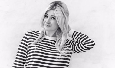  60 'lar-70' ler görünüşü. Sarışın kadın makyaj malzemesi çizgili kazak, modaya uygun bir konsept.