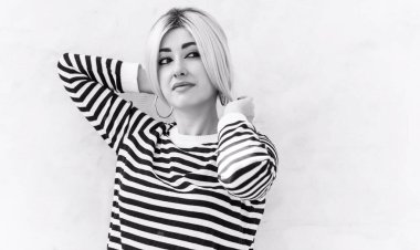  60 'lar-70' ler görünüşü. Sarışın kadın makyaj malzemesi çizgili kazak, modaya uygun bir konsept.