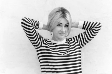  60 'lar-70' ler görünüşü. Sarışın kadın makyaj malzemesi çizgili kazak, modaya uygun bir konsept.