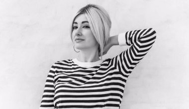  60 'lar-70' ler görünüşü. Sarışın kadın makyaj malzemesi çizgili kazak, modaya uygun bir konsept.