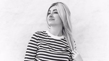  60 'lar-70' ler görünüşü. Sarışın kadın makyaj malzemesi çizgili kazak, modaya uygun bir konsept.