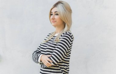 60 'lar-70' ler görünüşü. Sarışın kadın makyaj malzemesi çizgili kazak, modaya uygun bir konsept.