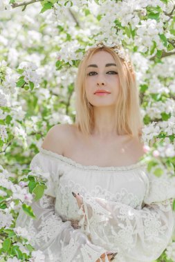 Bahar bahçesinde gelin. Makyajlı ve çiçekli romantik dantelli yarışçı kadın.