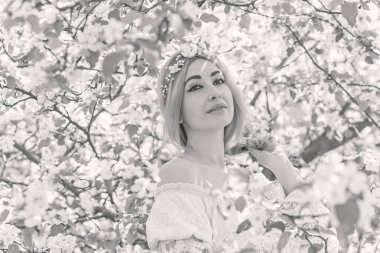 Bahar bahçesinde gelin. Makyajlı ve çiçekli romantik dantelli yarışçı kadın.