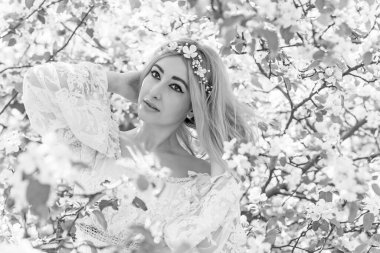 Bahar bahçesinde gelin. Makyajlı ve çiçekli romantik dantelli yarışçı kadın.