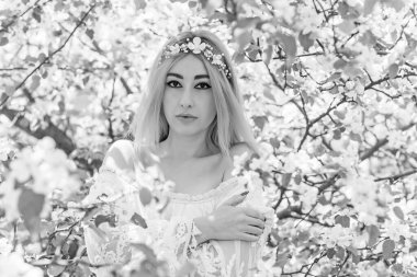 Bahar bahçesinde gelin. Makyajlı ve çiçekli romantik dantelli yarışçı kadın.