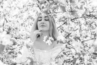 Bahar bahçesinde gelin. Makyajlı ve çiçekli romantik dantelli yarışçı kadın.